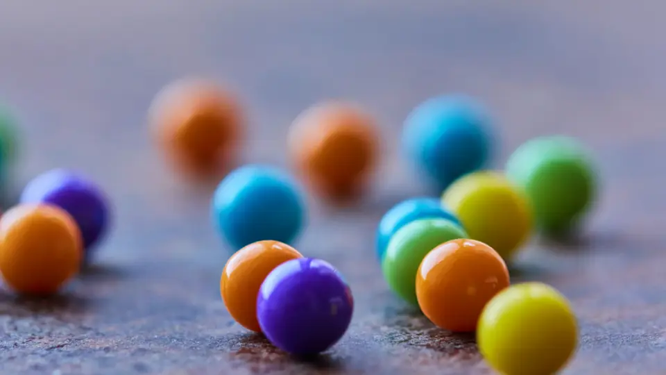 Kleine bunte Bonbonkugeln auf einer grauen Fläche