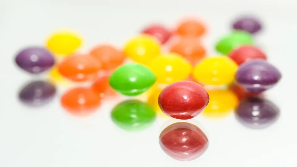 Bunte Dragees in einem kleinen Haufen auf hellem Grund